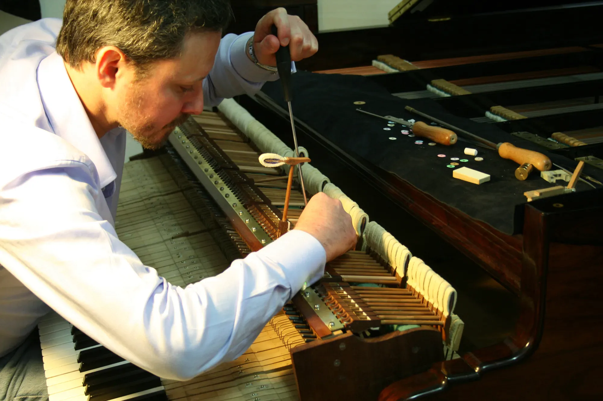 Interno di un pianoforte a coda Boisselot&Fils - Regolazione della meccanica.